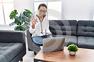 Young hispanic woman having teleconsultation psychology session at psychology clinic