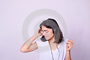 Young hispanic woman listening to music with headphones