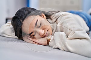 Young hispanic woman lying on sofa sleeping at home