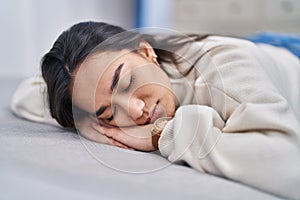 Young hispanic woman lying on sofa sleeping at home