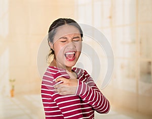 Young hispanic woman posing for camera showing signs of shoulder pain, holding hands on painful body part, injury