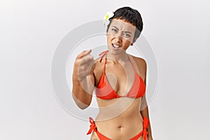 Young hispanic woman with short hair wearing bikini pointing displeased and frustrated to the camera, angry and furious with you