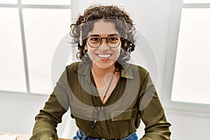 Young hispanic woman smiling confident wearing headset working at office