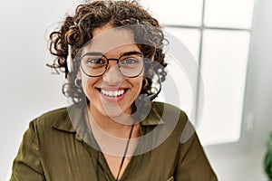 Young hispanic woman smiling confident wearing headset working at office