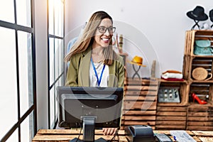 Young hispanic woman smiling confident working at clothing store