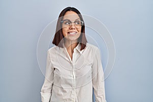 Young hispanic woman standing over white background smiling looking to the side and staring away thinking