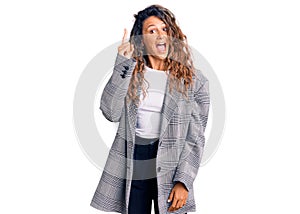 Young hispanic woman with tattoo wearing business oversize jacket pointing finger up with successful idea