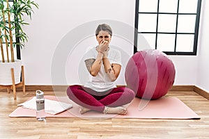 Young hispanic woman training at sport center smelling something stinky and disgusting, intolerable smell, holding breath with