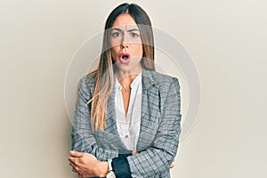 Young hispanic woman wearing business clothes afraid and shocked with surprise expression, fear and excited face