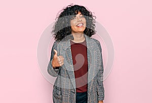 Young hispanic woman wearing business clothes doing happy thumbs up gesture with hand