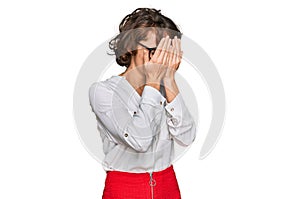 Young hispanic woman wearing business style and glasses with sad expression covering face with hands while crying