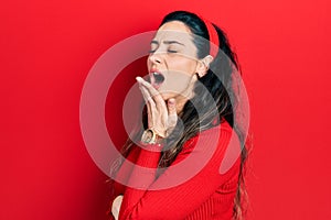 Young hispanic woman wearing casual clothes bored yawning tired covering mouth with hand