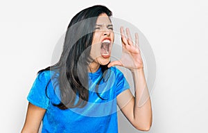 Young hispanic woman wearing casual clothes shouting and screaming loud to side with hand on mouth