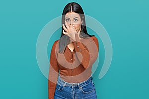 Young hispanic woman wearing casual clothes smelling something stinky and disgusting, intolerable smell, holding breath with