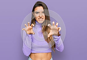 Young hispanic woman wearing casual clothes smiling funny doing claw gesture as cat, aggressive and sexy expression