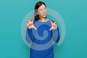 Young hispanic woman wearing casual clothes smiling funny doing claw gesture as cat, aggressive and sexy expression