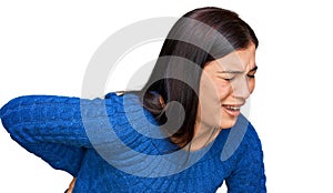 Young hispanic woman wearing casual clothes suffering of backache, touching back with hand, muscular pain
