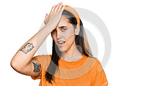 Young hispanic woman wearing casual clothes surprised with hand on head for mistake, remember error
