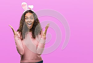 Young hispanic woman wearing easter bunny ears very happy and excited, winner expression celebrating victory screaming with big