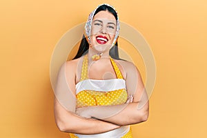 Young hispanic woman wearing pin up style happy face smiling with crossed arms looking at the camera