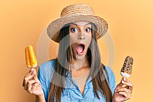 Young hispanic woman wearing summer style holding ice cream afraid and shocked with surprise and amazed expression, fear and