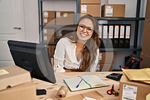 Young hispanic woman working at small business ecommerce happy face smiling with crossed arms looking at the camera