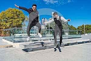 Young Hispanics having fun and jumping from a bench in a public park photo