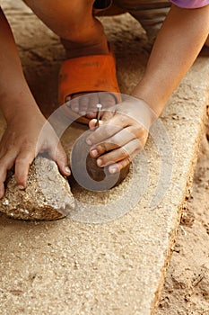 young Hmong boy playing with his homemade timber spinning top