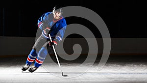 Young hockey player skating on rink in attack