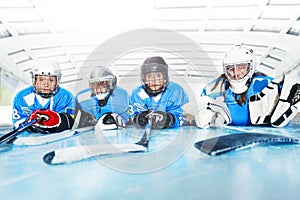 Young hockey players laying on ice rink in line