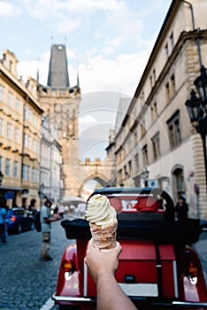 Young holding trolo ice cream against cityscape of Prague