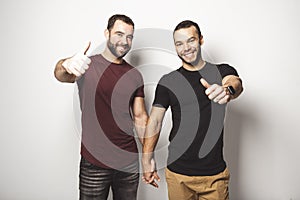 Young homosexuals gay couple love each other on a white background.