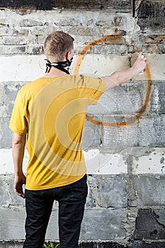 Young hooligan drawing a graffiti