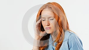 Young hopeless red hair woman suffering from depression having nervous breakdown holding her head on isolated background, copy