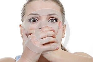 Young horrified woman closing her mouth with hands