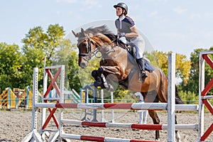 Young horse rider girl on show jumping competition