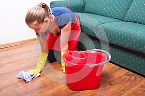 Young housekeeping lady wiping the wooden floor