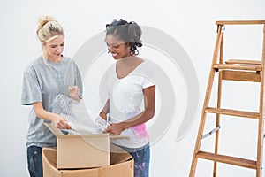 Young housemates unpacking moving boxes