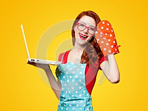 Young housewife with computer and oven gloves