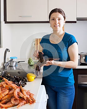 Young housewife cooking sea food