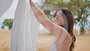 Young housewife hanging laundry sun beams rural nature closeup. Portrait woman