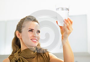 Young housewife looking on glass of water