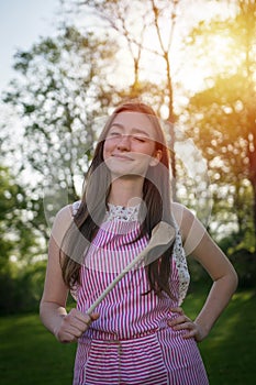 Young housewife with spoon in a natural environment