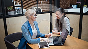 Young HR woman interviews a candidate for a job. Business meeting two young women at work discussing the project