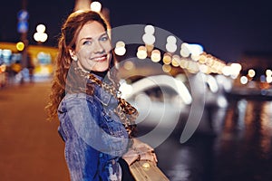 Young hungarian woman smiling on Margaret Bridge at night Budapest
