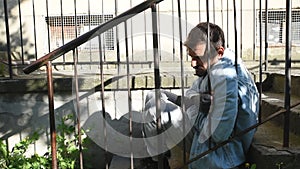 Young hungry sick and depressed homeless man sitting on the stairs of the building in the city street to rest after searching