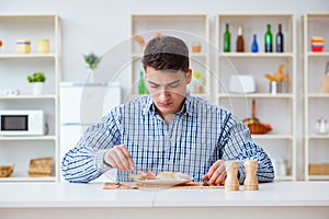 The young husband eating tasteless food at home for lunch