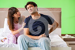 The young husband having problems with health in bedroom