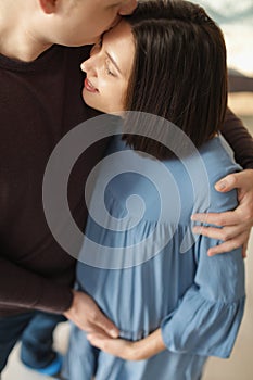 Young husband hugging his pregnant wife