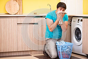 The young husband man doing laundry at home